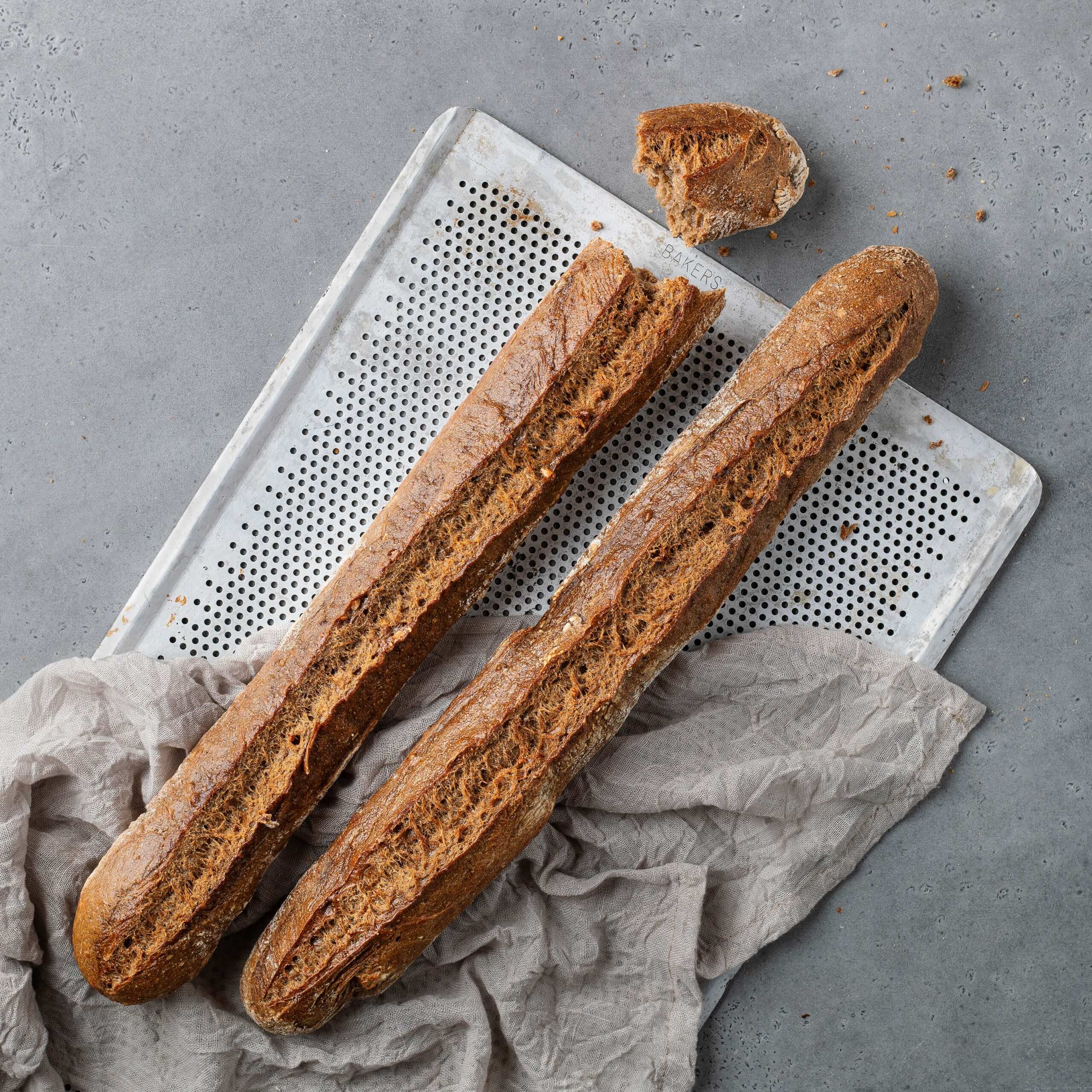 Baguette Rustique - två st mörka surdegsbaguetter på en plåt | Dahls Bageri